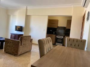 uma sala de estar com mesa e cadeiras e uma cozinha em Bahga Palace 5 Residential Apartments em Hurghada