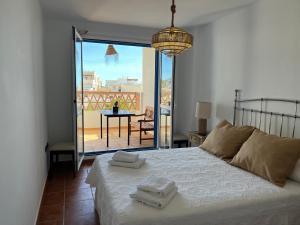 Un dormitorio con una cama con vista a un balcón. en Isleta 5, en La Isleta del Moro