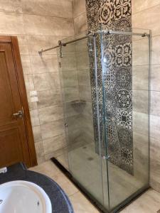 a shower with a glass door next to a sink at Bahga Palace 5 Residential Apartments in Hurghada +30 photos