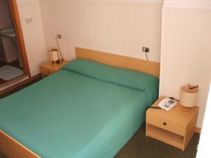 ein Schlafzimmer mit einem grünen Bett und einem Telefon in der Unterkunft Hotel Cucciolo in Donoratico + 56 Fotos