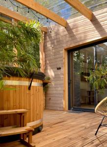 une terrasse en bois avec une porte coulissante en verre. dans l'établissement Madame Imagine, Lodges & SPA Epinal, à Épinal