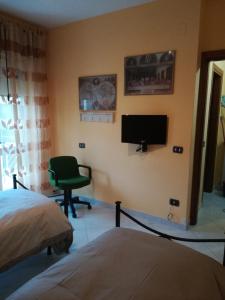 テレーゼにあるB&B Serenitàのベッドルーム(ベッド1台、テレビ、椅子付)