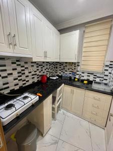 a kitchen with white cabinets and black counter tops at Ucal Apart in Istanbul