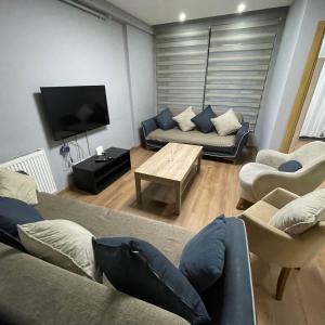 een woonkamer met een bank en een tv bij Taksim Elysium Residence in Istanbul