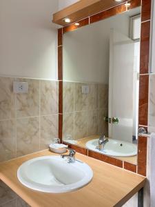 uma casa de banho com um lavatório branco e um espelho. em Hotel La Posada Del Ingles em Chiclayo