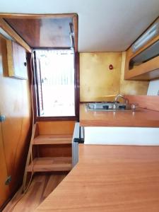 eine kleine Küche mit einem Waschbecken und einem Fenster in der Unterkunft Gianna 'S boat pozzuoli in Monterusciello