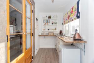 a kitchen with white walls and a wooden counter top at Braemar House in Oamaru