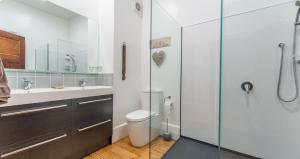 a bathroom with a toilet and a glass shower at Braemar House in Oamaru