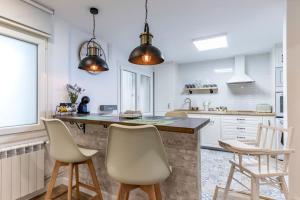a kitchen with white walls and a large island with chairs at Apt in the Old Town with cool Terrace!! Private Parking in Bilbao