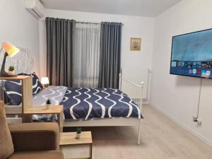 - une chambre avec un lit et une télévision à écran plat dans l'établissement Ghencea Residence 158 L2, à Bucarest
