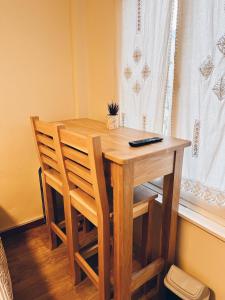 a wooden table with two chairs sitting next to a window at Ulen in Ushuaia