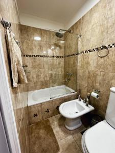 uma casa de banho com uma banheira, um WC e um lavatório. em Ulen em Ushuaia