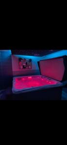 a bed with a red light on top of it at Escapade Normande SPA in Yerville