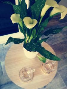 un jarrón con flores blancas en una mesa en Escapade Normande SPA, en Yerville