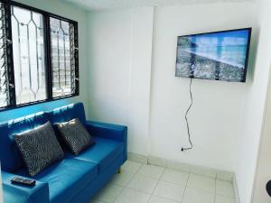 a blue couch in a living room with a tv at Apartamento GUATAPE in Guatapé