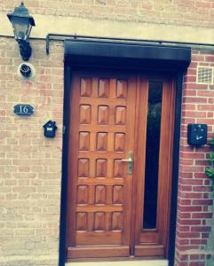 drewniane drzwi na boku budynku z cegły w obiekcie Escapade Normande SPA w mieście Yerville