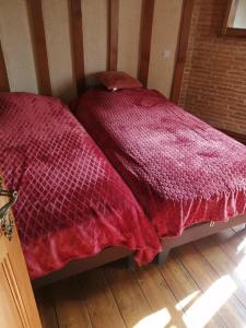 a bedroom with two beds with red comforters on them at Escapade Normande SPA in Yerville