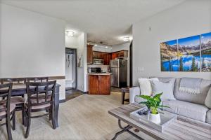 a living room and kitchen with a couch and a table at Outstanding Mountain Condo *WATERSLIDE* HOTTUB* hosted by Fenwick Vacation Rentals in Canmore