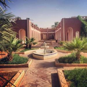 a courtyard with a fountain in the middle of a building at Résidence Tin Habib in Timimoun