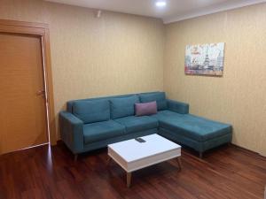 a living room with a blue couch and a table at Taksim Elysium Residence in Istanbul