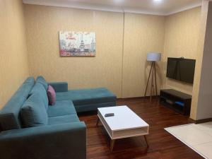 イスタンブールにあるTaksim Elysium Residenceのリビングルーム(青いソファ、テレビ付)