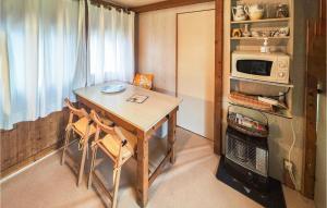 una pequeña cocina con mesa y microondas en 2 Bedroom Lovely Home In Ferrires-poussarou, en Ferrières-Poussarou