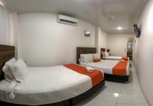 1 Schlafzimmer mit 2 Betten in einem Zimmer in der Unterkunft Hotel Royal Classy in Villavicencio