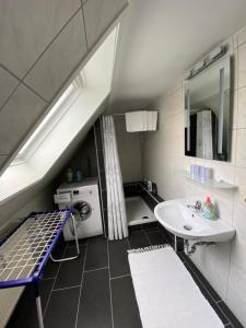La salle de bains est pourvue d'un lavabo et d'un lave-linge. dans l'établissement Apartment Q im Zentrum von Königsbronn, à Königsbronn