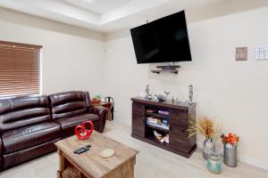 a living room with a leather couch and a flat screen tv at Harbor Island Retreat in Port Isabel
