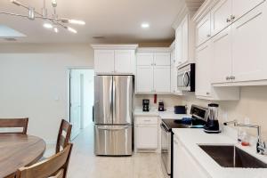a kitchen with white cabinets and a stainless steel refrigerator at Harbor Island Retreat in Port Isabel