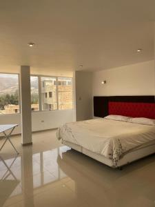 1 dormitorio con 1 cama grande y cabecero rojo en Hotel Casa Blanca Huacariz en Cajamarca