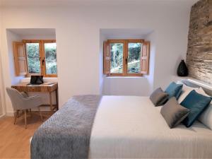 1 dormitorio con 1 cama grande, escritorio y ventanas en Apartamento con encanto en centro histórico Lugo -TineriaLucusHome, en Lugo