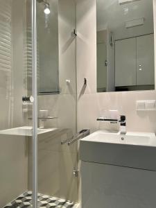a bathroom with a glass shower and a sink at Comfortable apartments Warsaw West IV in Warsaw