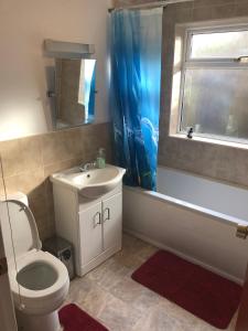een badkamer met een toilet, een wastafel en een bad bij Spacious Furnished Bungalow with Garden n Parking in Bradenham