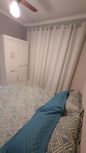 a bedroom with a bed and a window with a curtain at 113 SOL & MAR I com VARANDA - 1 dormitório - Canto do FORTE - 300 m da Praia e 20m da Avenida dos Barzinhos - ESTACIONAMENTO gratuito e WI Fi 300mbytes com TV a cabo - ap113 in Praia Grande