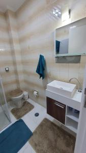 a bathroom with a sink and a toilet and a mirror at SOL & MAR I com VARANDA - 1 dormitório - Canto do FORTE - 300 m da Praia e 20m da Avenida dos Barzinhos - ESTACIONAMENTO gratuito e WI Fi 300mbytes com TV a cabo - ap113 in Praia Grande