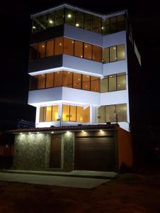 a tall building with a garage in front of it at night at Hotel Casa Blanca Huacariz in Cajamarca