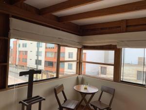 a room with a table and chairs and windows at El Refugio de Barranco in Lima