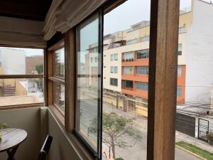 a room with windows with a view of a building at El Refugio de Barranco in Lima