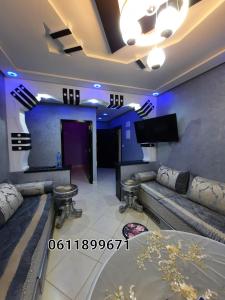 sala de estar con sofá y TV en اقامة سهيلة en Nador