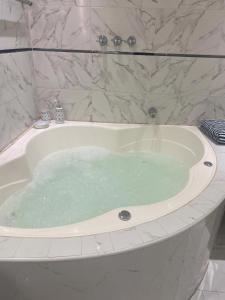 a bath tub filled with water in a bathroom at Hotel Casa Blanca Huacariz in Cajamarca