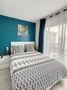 1 dormitorio con 1 cama grande y pared azul en STUDIO COSY HYPER CENTRE GARE AMIENS WIFI NETFLIX 2 PERS, en Amiens