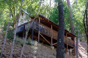 a wooden cabin in the woods with a staircase at Yosemite Bug Rustic Mountain Resort in Midpines