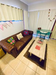 a living room with a brown couch and a table at Plaza Departamentos Temporarios in Formosa