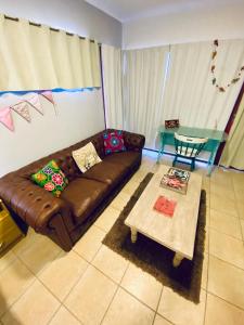 a living room with a brown couch and a table at Plaza Departamentos Temporarios in Formosa