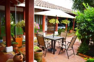 einen Tisch und Stühle mit Sonnenschirm auf einer Terrasse in der Unterkunft CASA GEMMA in Guaduas