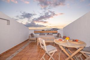 Pokój ze stołem i krzesłami na balkonie w obiekcie Port Royale Los Cristianos Arona w mieście Los Cristianos