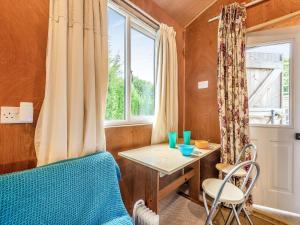 a small room with a table and a window at Shepherds Hut in Biddenden