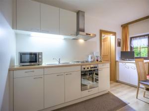 a kitchen with white cabinets and a microwave at Apartment in Top Location in F gen with Balcony in Fügen