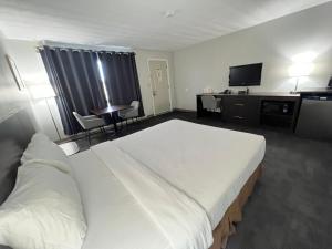 Habitación de hotel con cama grande y escritorio. en Travelodge by Wyndham Cochrane, en Cochrane
